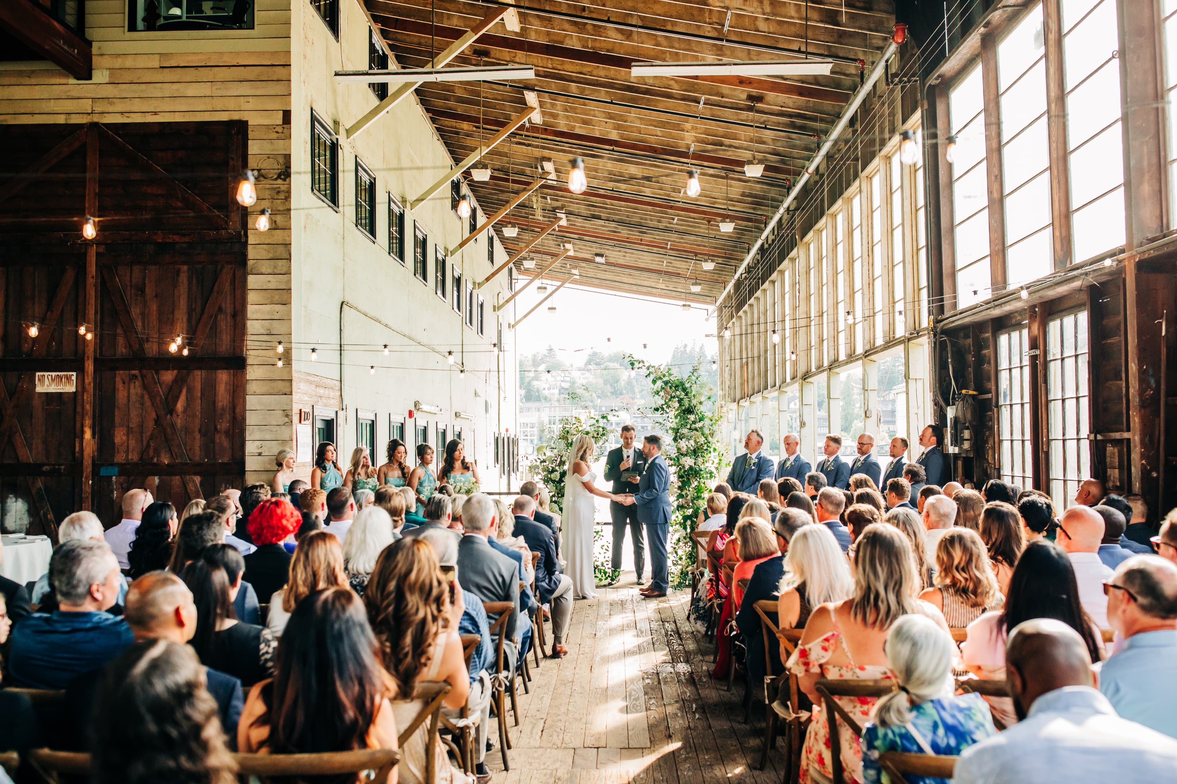 Rows of chairs lined with flowers down the ceremony aisle in the barn